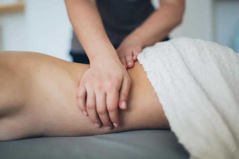 Fisioterapeuta realizando terapia manual en la zona lumbar en la clínica Rhabilita